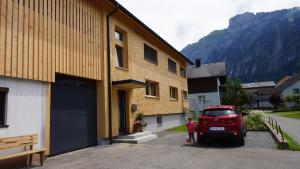 un coche rojo está estacionado junto a un edificio en Haus Edeltraud en Mellau