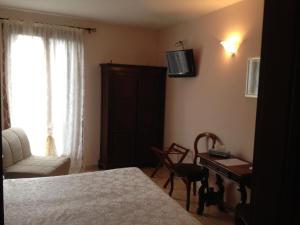 Schlafzimmer mit einem Bett, einem Schreibtisch und einem TV in der Unterkunft Hotel Locanda Salieri in Venedig
