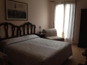 a bedroom with a bed and a chair and a window at Hotel Locanda Salieri in Venice
