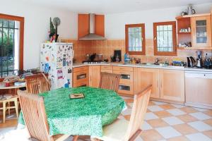 cocina con mesa, sillas y nevera en Villa au calme sans vis à vis en Fayence
