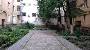 an alley in a city with buildings and trees at Apartment near the Forum mall in Lviv