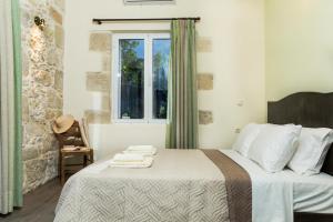 a bedroom with a bed with towels on it at Margarita's Stone House in Plátanos