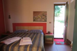 a small bedroom with a bed and a window at Agriturismo Capuano in Gangi