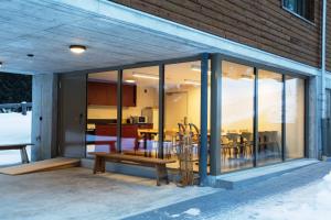 a glass house with a bench and a table at Sport- und Ferienhaus Don Bosco in Lenzerheide