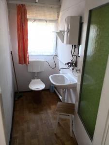 La petite salle de bains est pourvue de toilettes et d'un lavabo. dans l'établissement Domki letniskowe Delfin, à Mrzeżyno