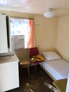 Cette petite chambre comprend un lit, une table et une fenêtre. dans l'établissement Domki letniskowe Delfin, à Mrzeżyno