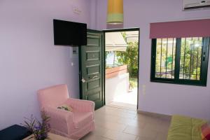 a living room with a green door and a chair at Elina Apartments in Parga