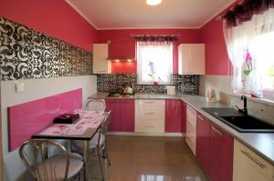 a kitchen with red walls and a table and chairs at Jagodowy Domek in Święta Katarzyna +30 photos