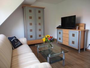 ein Wohnzimmer mit einem Sofa und einem Tisch mit Blumen in der Unterkunft Messe-/Ferienwohnung in Nürnberg