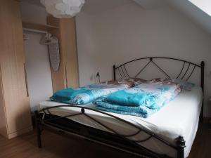 ein Bett mit blauen Decken auf einem Zimmer in der Unterkunft Messe-/Ferienwohnung in Nürnberg