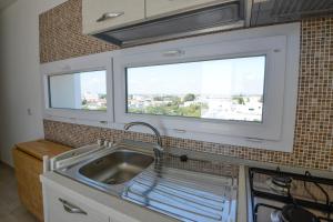a kitchen with a sink and two windows at Case Sangiorgio in Ginosa Marina +49 photos