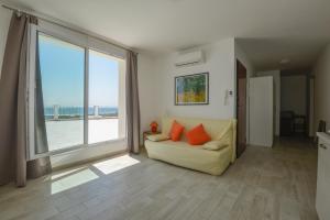 a living room with a couch and a large window at Case Sangiorgio in Ginosa Marina