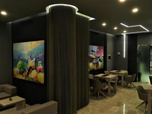 une salle à manger avec des tables et des peintures sur les murs dans l'établissement International Beach Hotel, à Lignano Sabbiadoro