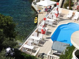 a row of chairs and umbrellas next to the water at Apartmani Tepli Bok in Primošten