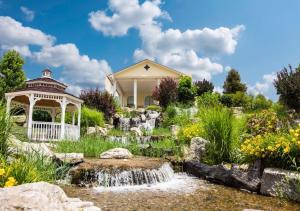a garden with a waterfall and a gazebo at Savannah House Hotel in Branson