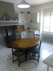 eine Küche mit einem Holztisch und Stühlen in der Unterkunft Slow Life House in Saint-Maurice-sous-les-Côtes