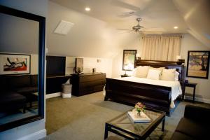 1 dormitorio con 1 cama y sala de estar en Black Lantern Inn en Roanoke