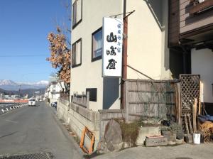 a building with a sign on the side of it at Yudanaka Onsen Yamazakiya in Yamanouchi