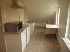 a small kitchen with a microwave and a table at 54 AV ROGERS MARTIN DU GARD in Bellême +23 photos
