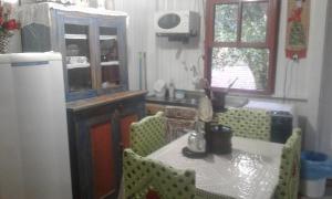cocina con mesa, sillas, mesa y nevera en Vovo Bebel, en Urubici