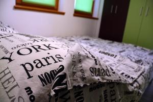 a bed with a comforter with words on it at Green Bear in Sarajevo
