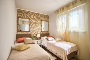 1 Schlafzimmer mit 2 Betten und einem Spiegel in der Unterkunft Apartment Sweetie center Pula with FREE PARKING - Hedone Amphitheater in Pula