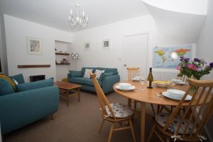 a living room with a table and a blue couch at Polly Cottage in Teignmouth