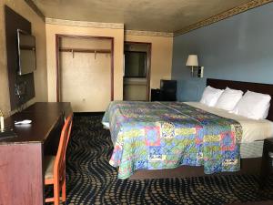 a hotel room with a bed and a desk at Deluxe Inn Kilgore in Kilgore