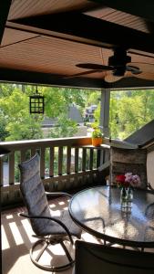 uma varanda com uma mesa de vidro e 2 cadeiras em Black Lantern Inn em Roanoke