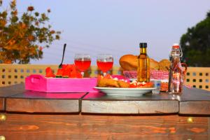 - une table avec deux verres de vin et une assiette de nourriture dans l'établissement Asteras Apartments, à Xerokampos