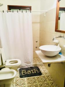 y baño con aseo, lavabo y ducha. en Lo de Lanny, en Colonia del Sacramento