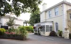 a white house with a lot of flowers in the driveway at Carlton Court in Torquay