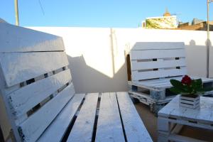 een houten bank en een potplant naast een tafel bij Al Madinah in Mazara del Vallo +2 foto's