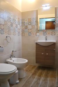 La salle de bains est pourvue d'un lavabo, de toilettes et d'un miroir. dans l'établissement Al Madinah, à Mazara del Vallo