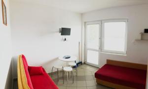 a living room with a red couch and a table at Dzika Róża in Karwia