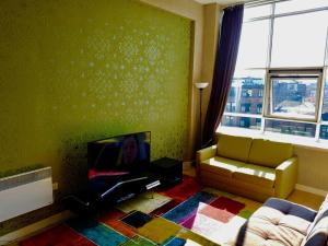 a living room with a flat screen tv and a couch at Glasgow City Center Flat with Parking in Glasgow