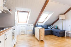 ein Wohnzimmer mit einem blauen Sofa im Dachgeschoss in der Unterkunft Fjord View Apartments in Stavanger