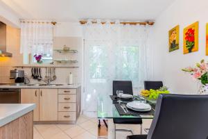 a kitchen with a table and chairs and a kitchen with a counter at Jasmina apartment in Rijeka