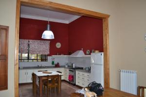 a kitchen with a table and a white refrigerator at Casa Mansa Puro Campo in Lobos
