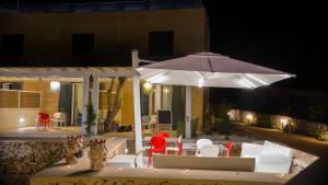 a white table topped with a white umbrella at Le Suites del Carrubo in Favignana