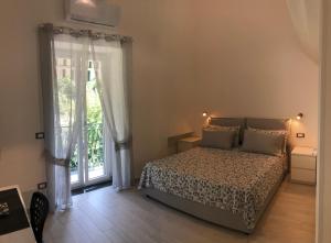 a bedroom with a bed and a large window at Holiday House Ruocco in Maiori