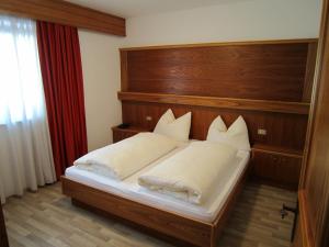 A bed or beds in a room at Aparthotel Garni Haus Hubertus