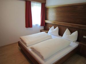 A bed or beds in a room at Aparthotel Garni Haus Hubertus