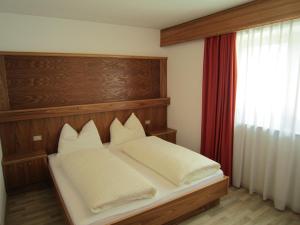 A bed or beds in a room at Aparthotel Garni Haus Hubertus