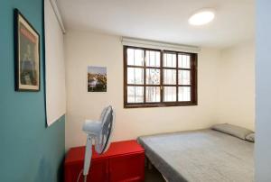 a bedroom with a bed and a window and a fan at Cozy Apartment in the Carmel Center in Haifa