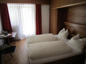 A bed or beds in a room at Aparthotel Garni Haus Hubertus