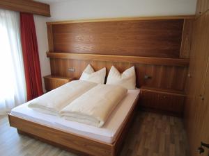 A bed or beds in a room at Aparthotel Garni Haus Hubertus