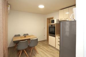 a kitchen with a table and chairs and a refrigerator at Nona Zena in Korčula
