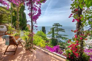 a room with a view of the ocean and flowers at Casa Passalacqua in Positano