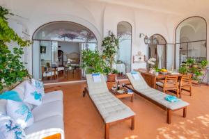 een woonkamer met witte meubels en een tafel bij Casa Passalacqua in Positano